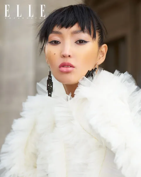 Model with a dark fringe and a white ruffled collar, on an ELLE Kazakhstan page